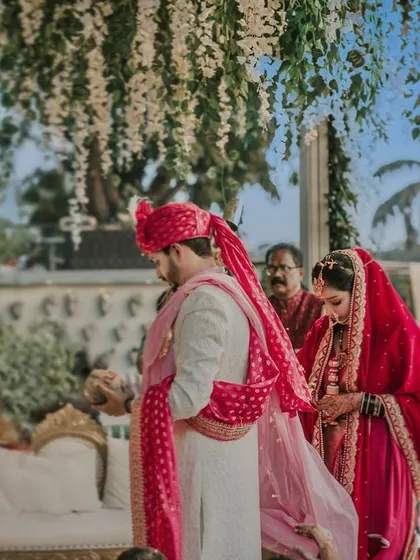 An intimate moment during the pheras. This close-up shot captures the couple's focus and the traditional elements of the Hindu wedding ceremony.