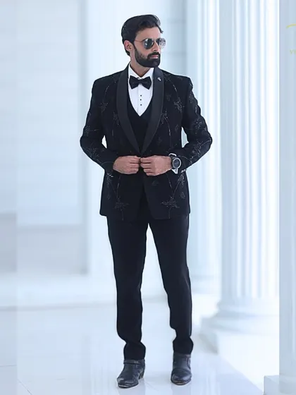 A full view of the custom black tuxedo, showing the balance between the detailed embroidery and the clean, tailored lines of the suit.