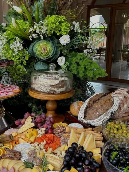 An angle highlighting the abundance of the spread, from fresh grapes and charcuterie to artisanal breads and pastries.