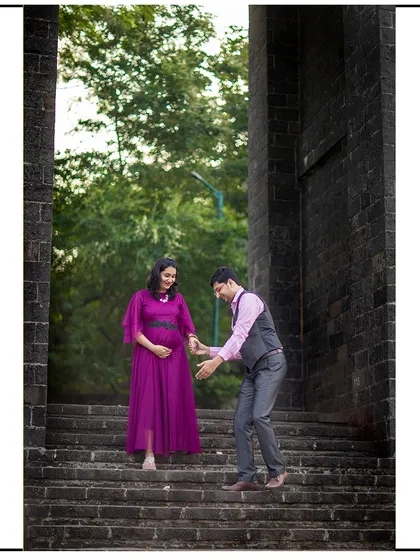 A tender moment as the dad-to-be helps his partner down the stairs, showcasing their connection and his support.
