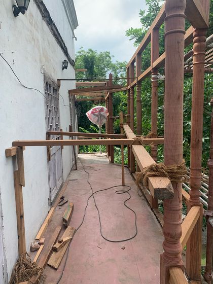 The process of restoring a timber balcony, with the new wooden framework being carefully assembled on-site.