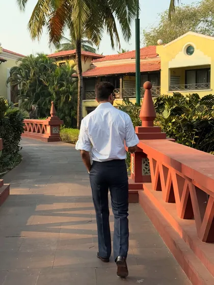 A walking shot from the back, showcasing the shirt's relaxed drape and how it pairs perfectly with dark, tailored trousers.
