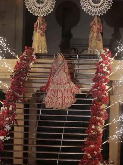 The bride's majestic walk down a staircase lined with flowers and cold pyros. We design these entries to be a visual spectacle from every angle.