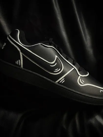 A pair of black Nike Ebernon sneakers with the same bold, white-outline cartoon effect.
