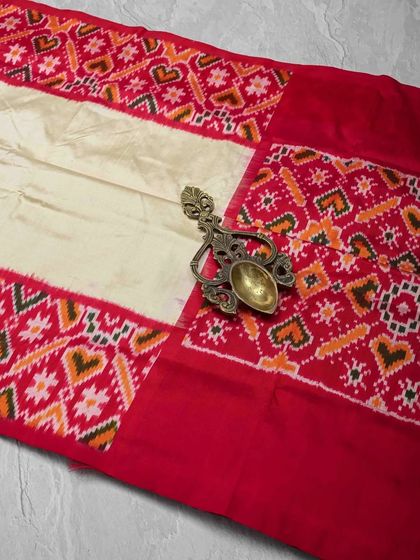 A beautiful single Ikkat silk saree in cream and red. The heart motifs woven into the border add a charming and unique touch to this traditional piece.