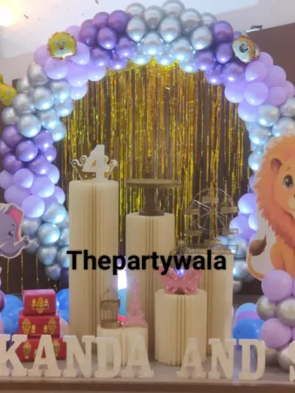 A jungle theme with a purple and silver twist! The animal cutouts look great against the unique color combination of the balloon arch.