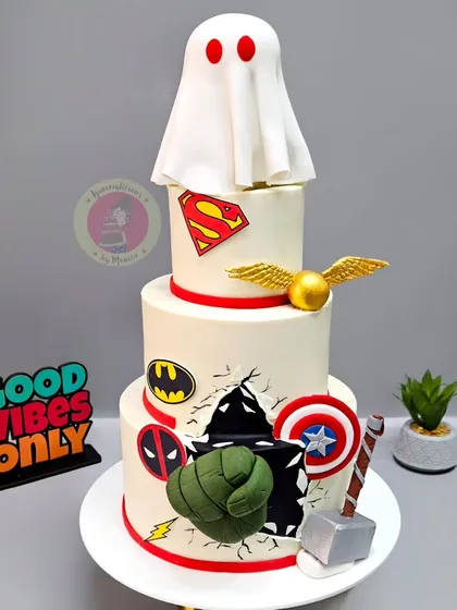 A three-tier cake made for The Souled Store's anniversary, featuring their iconic ghost logo alongside superhero and Harry Potter symbols.
