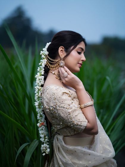 A festive Sankranti-themed shoot. The model is dressed in a traditional white saree, with jasmine flowers in her hair, creating a culturally rich and visually appealing portrait.