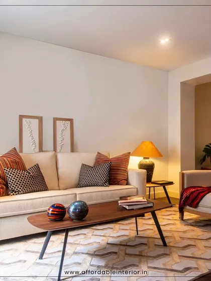 A cozy living room setup with a neutral sofa, patterned cushions, and warm lamplight, creating an inviting and comfortable atmosphere.