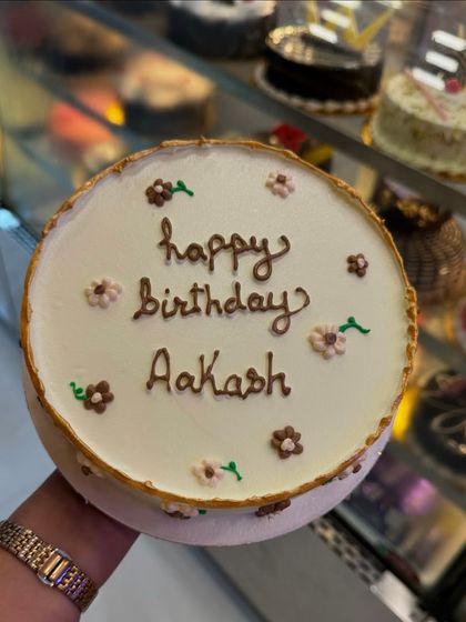 A simple and sweet custom birthday cake for Aakash. The minimalist design with delicate floral details shows that sometimes, less is more.