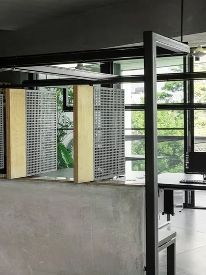 The main studio floor at 'Project 113' features custom-designed workstations and partitions made of perforated steel and birch ply. These elements divide the space lightly, maintaining an open, collaborative atmosphere while providing a degree of personal space.