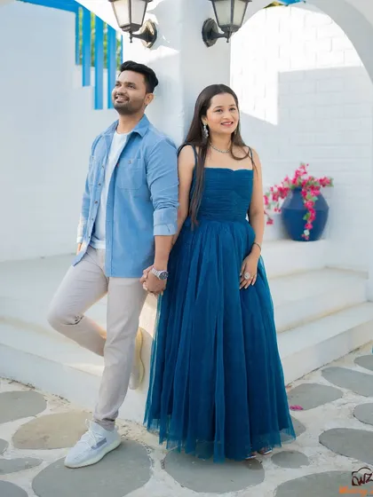 A stylish, full-length portrait of Jui and Vaikrant at a themed location. This shot showcases their casual yet coordinated pre-wedding outfits.