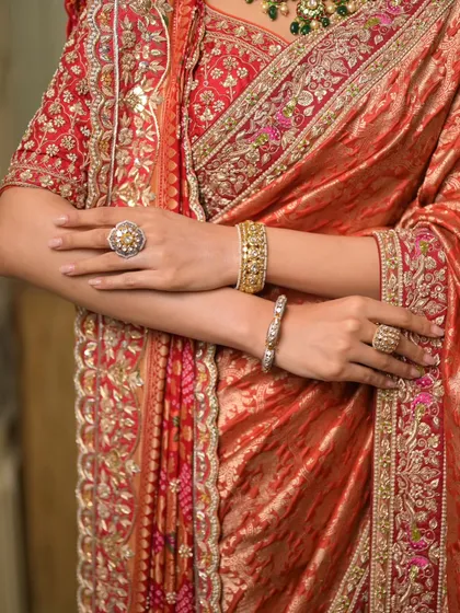A detailed shot of the pallu and blouse, showing the incredible craftsmanship of the hand-embroidered fabric.