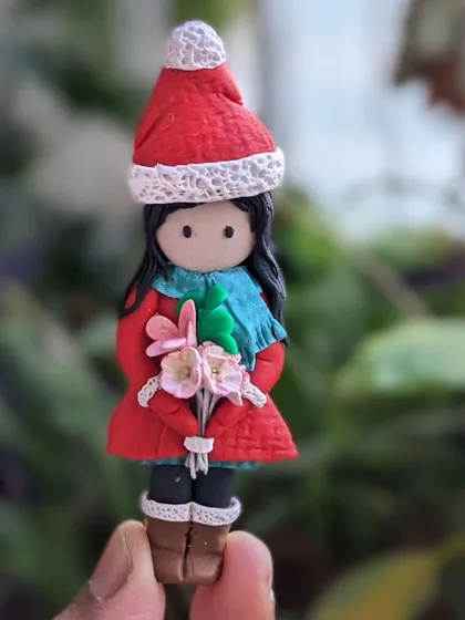 I missed posting this sweet little winter girl on my feed. She's all dressed up in her red coat and holding a bouquet of flowers.