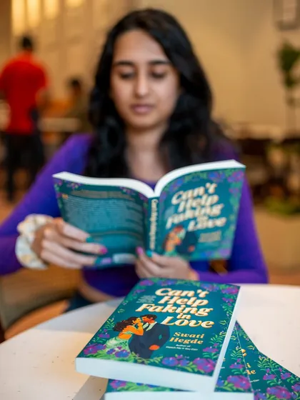Another shot of me reading *Can't Help Faking in Love*. This book is set in my hometown of Bangalore and is full of local flavor.