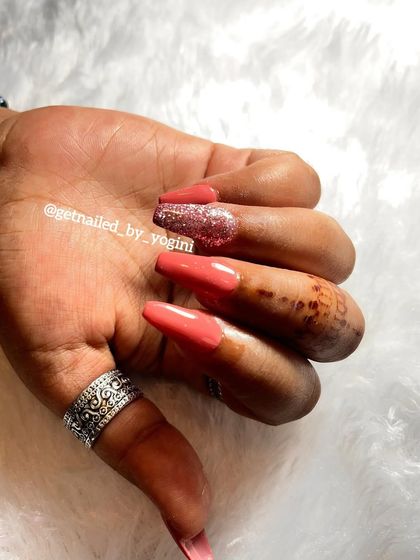 A stunning set of long, coffin-shaped acrylic extensions. I used a beautiful coral-pink gel polish and a full-coverage silver glitter accent nail for a bold and glamorous look.