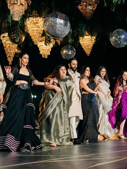 A fun moment from a group performance where the groom is surrounded by the ladies of the family. We choreograph these playful 'jugalbandi' style interactions between different family groups.