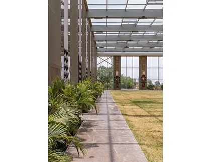 A view from inside the Glass Pavilion, looking out. The minimal structure and extensive use of glass create a strong connection to the surrounding environment, while the manicured lawn provides a versatile surface for events.