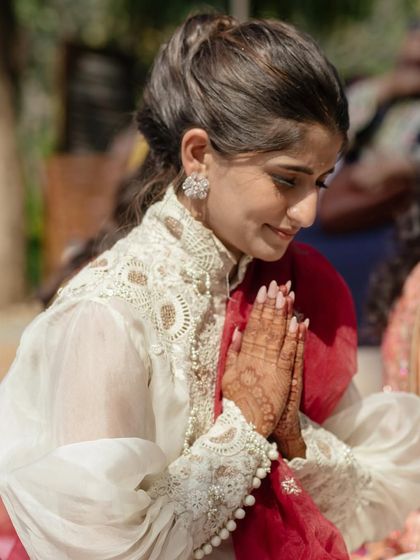 A close-up of Sneha during the Pooja, showing the delicate lace and pearl details on her Anamika Khanna kurta. A look of pure grace.