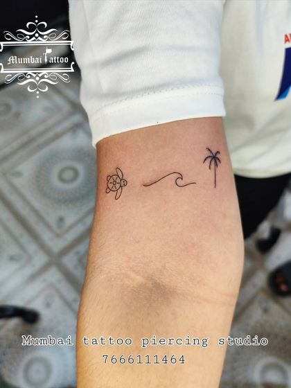 A perfect holiday tattoo, this minimal design features a turtle, a wave, and a palm tree. It’s a simple, clean-lined reminder of the ocean and tropical vibes.