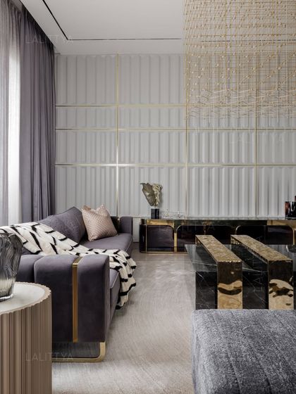 This corner of the entertainment lounge showcases our love for texture and metallic accents. A fluted wall panel is paired with a dark marble and brass console, while the velvet sofa adds a layer of plush comfort.