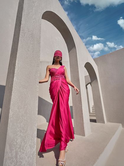 This pink pre-draped sari gown is designed for the woman on the go. It offers all the glamour of a sari with none of the fuss, featuring a sculpted bodice and an effortless drape.