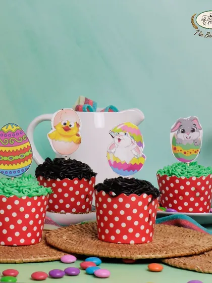 An assortment of Easter cupcakes in vanilla, chocolate, and butterscotch, decorated with cute Easter-themed toppers.