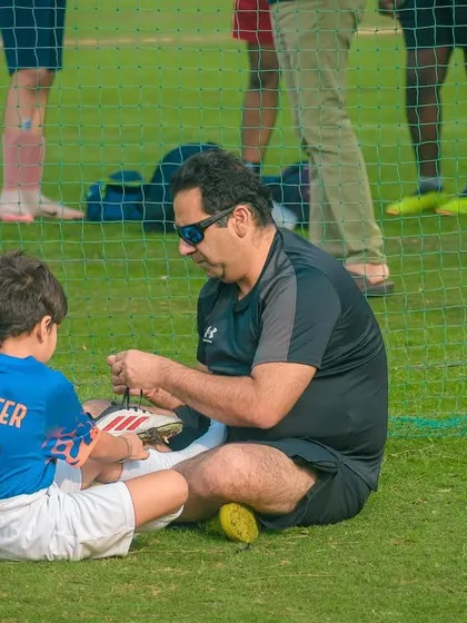 Sport is a family affair. I love seeing moments like this, where a father helps his son get ready for the big game, showcasing the supportive community we foster.