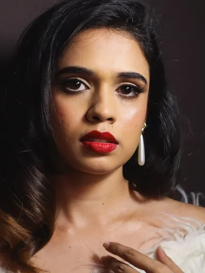 A direct portrait capturing the full effect of the 1950s glamour makeup. The combination of a flawless matte-yet-radiant base, a crisp red lip, and dramatic lashes is always a showstopper.