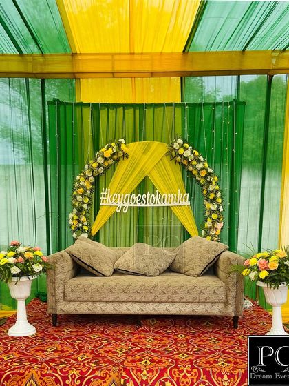 The clean and elegant Mehndi stage, ready for the couple. The combination of green, yellow, and a traditional carpet creates a classic and festive feel.