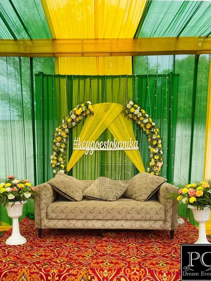 The clean and elegant Mehndi stage, ready for the couple. The combination of green, yellow, and a traditional carpet creates a classic and festive feel.