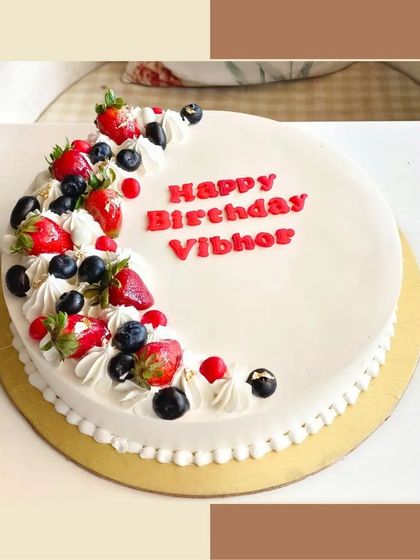 A simple and elegant fresh fruit cake, topped with fresh strawberries and blueberries.