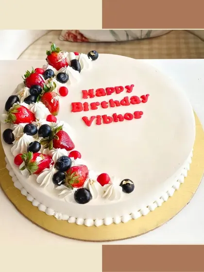 A simple and elegant fresh fruit cake, topped with fresh strawberries and blueberries.