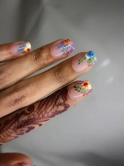 A simple and cute design with tiny, colorful flowers painted on natural nails.