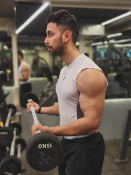 Embracing the burn and redefining my limits. A shot of a bicep curl with an EZ bar, which can be more comfortable on the wrists while still providing a great stimulus for muscle growth.