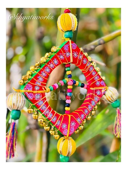 A close-up of the kite wall hanging, showing the intricate threadwork and the tiny ghungroos that add a musical touch.