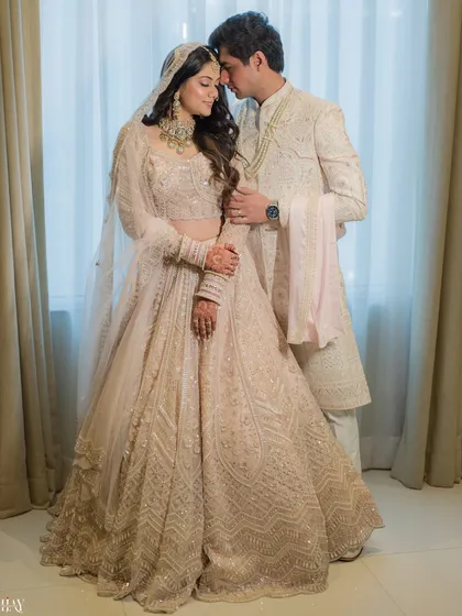 A regal and elegant portrait of the couple in their coordinated white and silver wedding attire, exuding timeless grace.