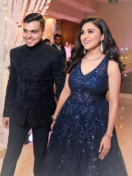 A candid moment of happiness during an engagement ceremony. We focus on capturing the natural chemistry between a couple, like this shot of them entering the venue, hand-in-hand, with genuine smiles.