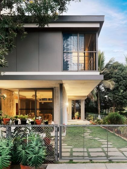 "Casa Magnifera" is a study in modern tropical architecture. The design features a simple cubic form with a cantilevered upper level, using a palette of grey cement board and exposed concrete to blend with the lush green surroundings.