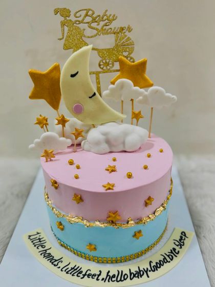 Another beautiful "Twinkle Twinkle" baby shower cake, with a sleeping moon nestled in fondant clouds and surrounded by golden stars.