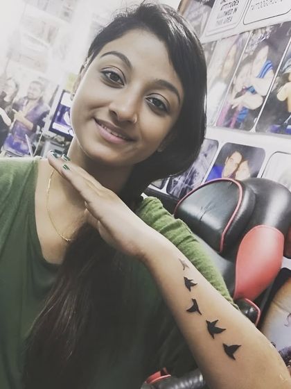 A silhouette of birds in flight on the forearm.