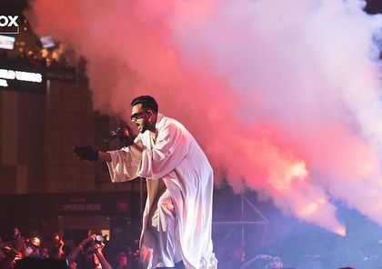 King making a dramatic entrance on stage, surrounded by a blast of smoke. Every moment is crafted for maximum impact.