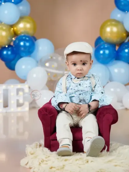 Looking very distinguished in his little armchair, this birthday boy is the center of attention in his special setup.