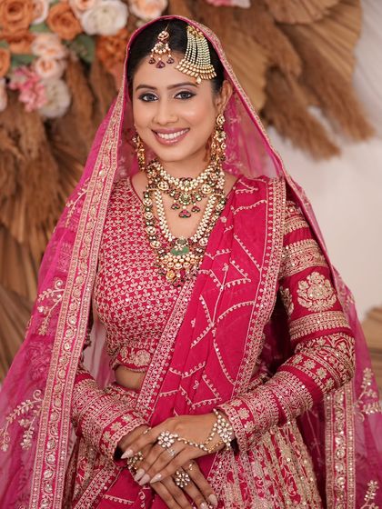 A complete bridal look featuring a heavy, gold-plated Kundan necklace, haath phool, and maang tikka, all available for rent.