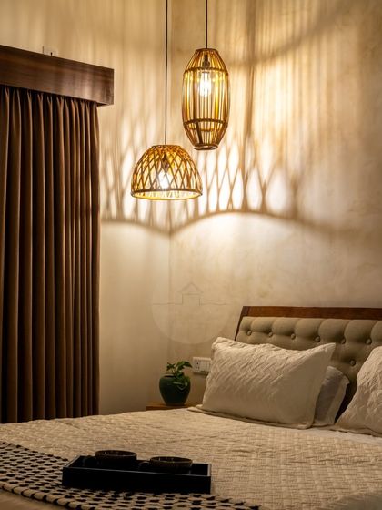 The magic of lighting in a master bedroom. This photo shows how the warm glow from the rattan pendant lights creates dramatic shadows on the textured wall, transforming the space into an intimate and cozy retreat at night.