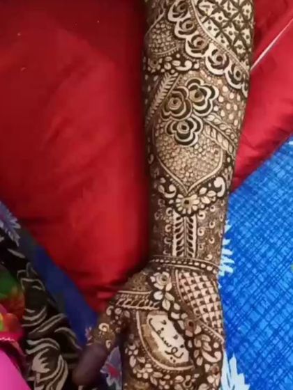 This bridal arm design features a mix of styles, including a portrait-like motif, floral patterns, and the groom's name, Yusuf, written in Arabic script.
