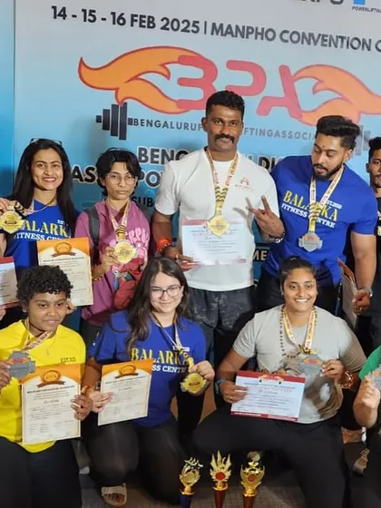 This is Team Balarka. My pride isn't just in my own lifts, but in the success of my athletes. Here we are after dominating a district championship with 13 gold medals. I coach to build champions, and this picture shows our collective strength.