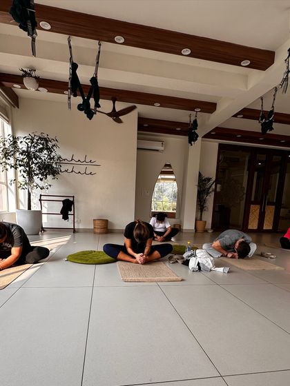 Students in a seated forward fold, a moment of quiet introspection during class.