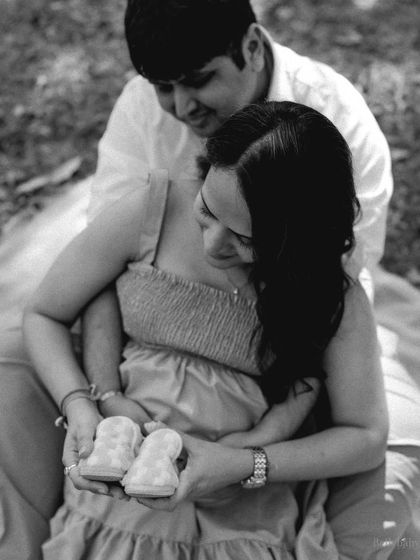 A beautiful black and white version of the couple holding the baby shoes together. It's a timeless portrait of their shared dream.