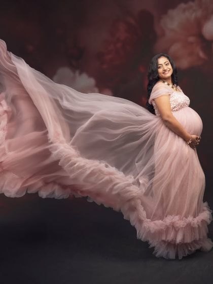 Feeling like a queen in this breathtaking pink maternity gown. This shot captures the essence of grace and the joy of motherhood, with a flowing train that feels like a dream.